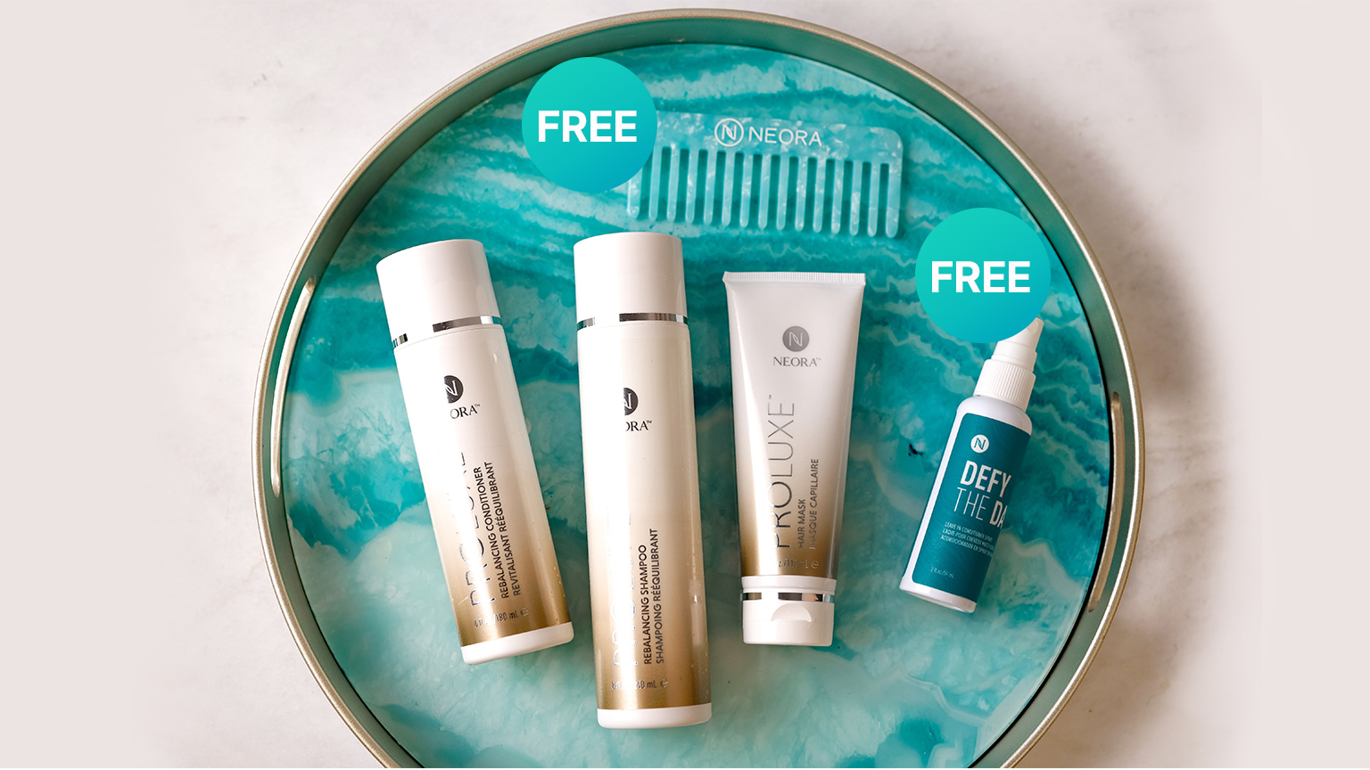 Neora’s Summer Hair Essentials Set, which includes ProLuxe Rebalancing Shampoo and Conditioner, Proluxe Hair Mask and a FREE Ultimate Detangling Comb and Defy the Day Leave-in Conditioner Spray laying on a turquoise plate